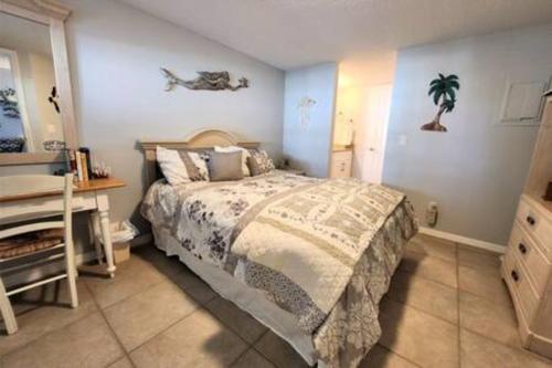 een slaapkamer met een bed en een bureau. bij Atrium Oceanview Condo - Sleeps 4 Guests 109 in Cape Canaveral