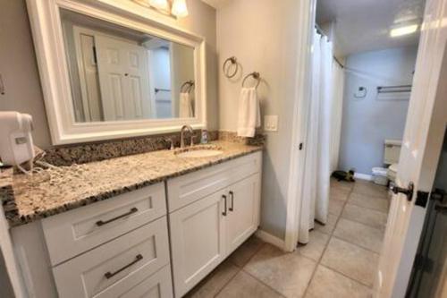 een badkamer met een wastafel en een spiegel bij Atrium Oceanview Condo - Sleeps 4 Guests 109 in Cape Canaveral