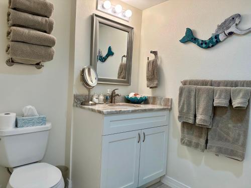 Un baño con lavabo, espejo e inodoro. en Patio Condo Deluxe 2br - Sleeps 5 Guests 312, en Cabo Cañaveral