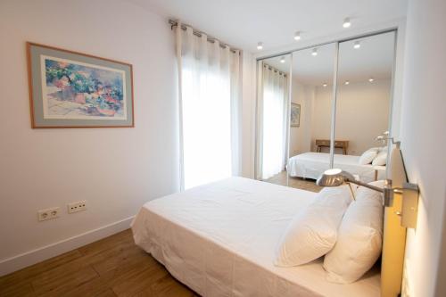 1 dormitorio con 2 camas y espejo en Ciencias Forum 2 Apartment by A3Rentals, en Granada