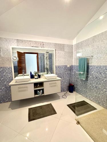 a bathroom with a sink and a mirror at COCO KASSOUMAÏ by LES VILLAS KASSOUMAÏ à 100m de la plage in Ngaparou