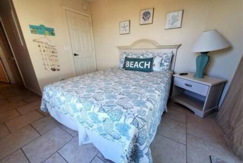 een slaapkamer met een bed en een tafel met een lamp bij Direct Oceanview Penthouse - Sleeps 6 301 in Cape Canaveral