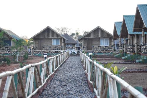 a row of wooden houses with a fence at Mowgli's Cafe Hampi & Guest House in Hampi