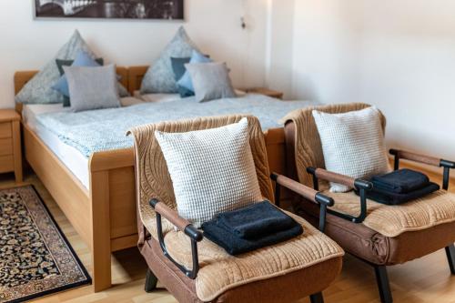 a bedroom with a bed with wicker chairs at Ferienwohnung Okertalerstieg in Goslar