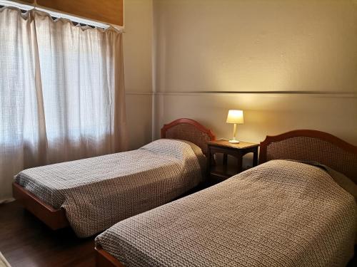 Zimmer mit 2 Betten und einer Lampe auf einem Tisch in der Unterkunft Flor de Loto in Durazno