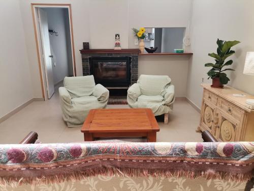 sala de estar con sofá, 2 sillas y chimenea en Flor de Loto, en Durazno