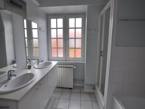 a white bathroom with two sinks and a window at LaTouqu in Le Touquet-Paris-Plage