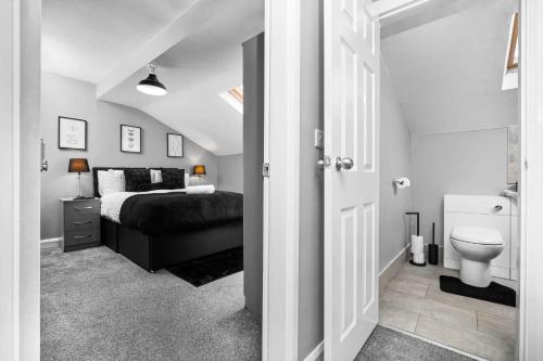 a bedroom with a bed and a toilet in it at Hotel comforts & home conveniences -sleeps 8 in Birmingham