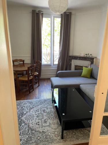 un salon avec un canapé et une table dans l'établissement Magnifique appartement au centre de Montrouge, à Montrouge