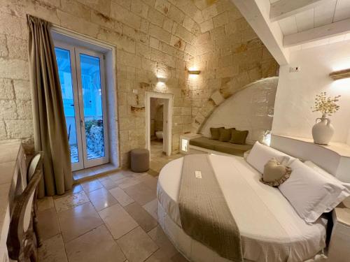 um quarto com uma cama grande numa parede de pedra em Vittorio Emanuele Charming Suites em Monopoli