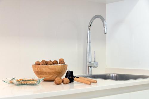 a kitchen counter with a bowl of nuts and a sink at Castell Beach Aparthotel in Castelldefels