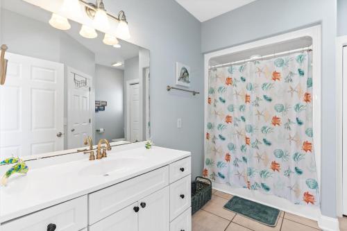 a bathroom with a sink and a shower curtain at Marsh Mellowed by the Sea Brunswick Vacation Rentals Privated heated pool and beach in Holden Beach