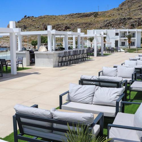 a row of benches sitting on a patio at Kamari Beach in Lardos