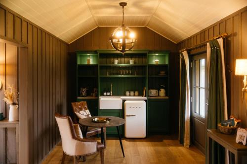 a kitchen with green cabinets and a small table at Retreat East in Ipswich