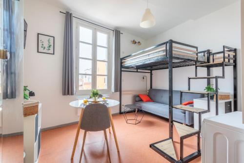 Ce petit appartement comprend des lits superposés et une table. dans l'établissement Studio calme et lumineux, à Aix-en-Provence