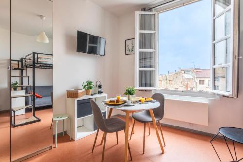 une salle à manger avec une table et des chaises et une fenêtre dans l'établissement Studio calme et lumineux, à Aix-en-Provence