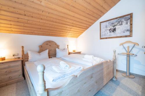 - une chambre avec un lit et un plafond en bois dans l'établissement Hornerblick, à Sonthofen