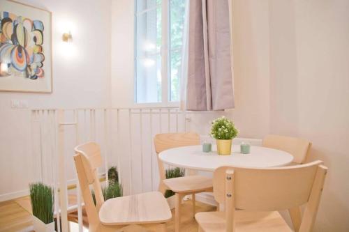 - une table et des chaises blanches dans la chambre dans l'établissement Luxury Apt Raspail Denfert, à Paris