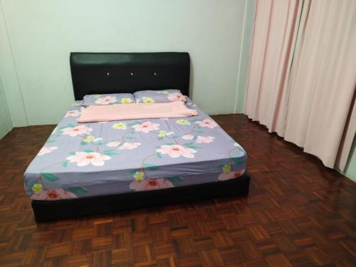 - un lit avec des draps roses et des fleurs dans l'établissement Sibu Homestay Tekam, à Sibu