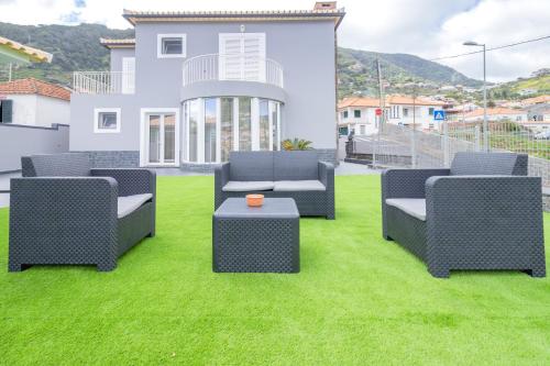 een tuin met vier stoelen en een tafel op het gras bij Villa Machico Valley in Machico