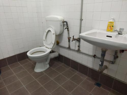 La salle de bains est pourvue de toilettes et d'un lavabo. dans l'établissement Sibu Homestay Tekam, à Sibu