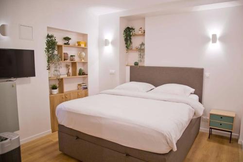 - une chambre avec un grand lit et des draps blancs dans l'établissement Luxury Apt Raspail Denfert, à Paris