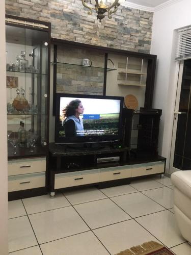 um centro de entretenimento com televisão numa sala de estar em Apartment em Shkodër