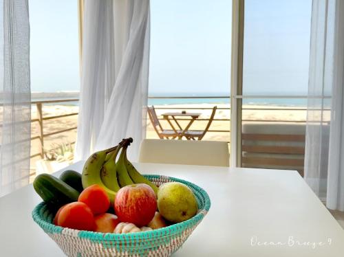 a bowl of fruit on a table with a view of the beach at Ocean Breeze 9 in Sal Rei