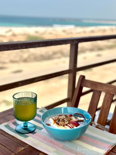 a bowl of food and a glass of juice on a table at Ocean Breeze 9 in Sal Rei