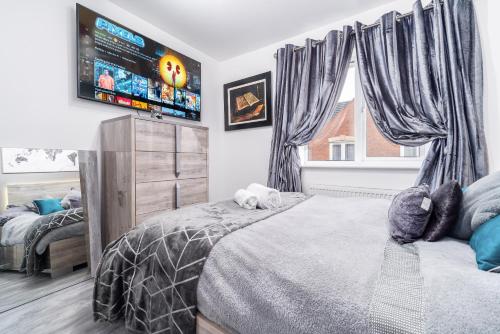 a bedroom with a bed and a flat screen tv at Stunning 2-Bed Apartment in Tipton Sleeps 3 in Tipton