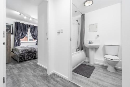 a bathroom with a toilet and a sink and a bath tub at Stunning 2-Bed Apartment in Tipton Sleeps 3 in Tipton
