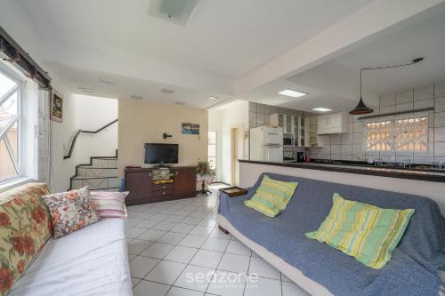 un soggiorno con divano e una cucina di Bela casa com piscina no centro de Penha/SC BSL190 a Penha