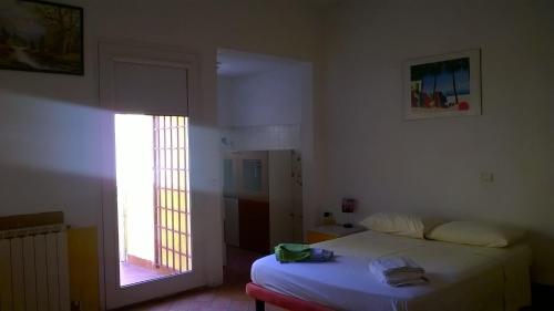 1 dormitorio con cama blanca y ventana en Colonna Home en Florencia