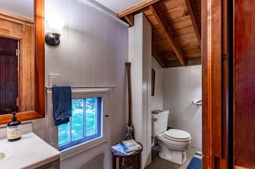a bathroom with a toilet and a window at The Doctor's Cottage - Vacation Back In-Time in Fremont
