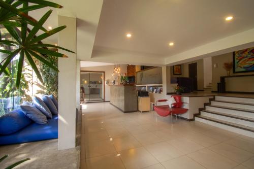 a living room with a blue couch and a kitchen at Hotel Barra da Lagoa by Latitud Hoteles in Búzios