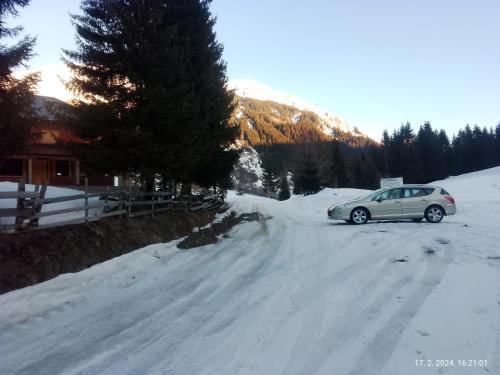 a car parked on the side of a snow covered road at Isov Ranch in Plav