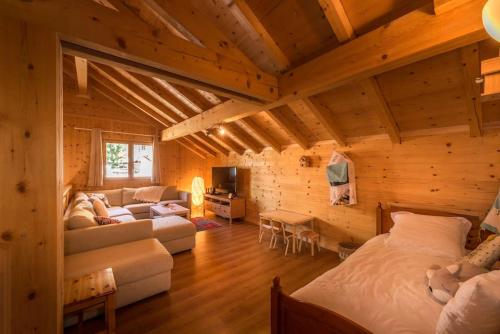 a room with two beds and a couch in a cabin at Chalet Bon Amour in Saint-Sorlin-dʼArves