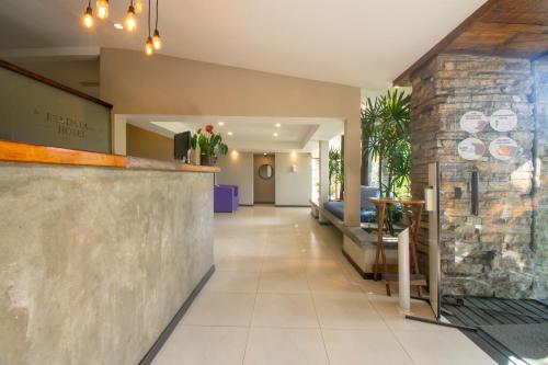 a lobby of a restaurant with a stone wall at Hotel Barra da Lagoa by Latitud Hoteles in Búzios