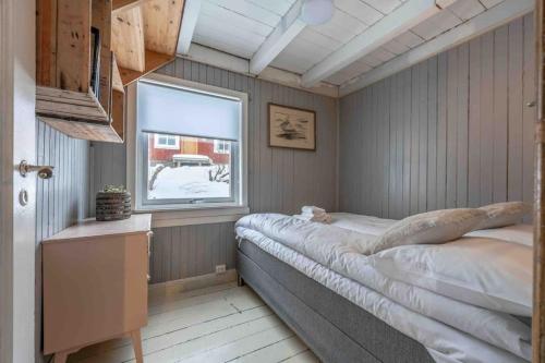 a bedroom with a large bed and a window at Reine Fishermans House - Mountain & Seaview in Reine