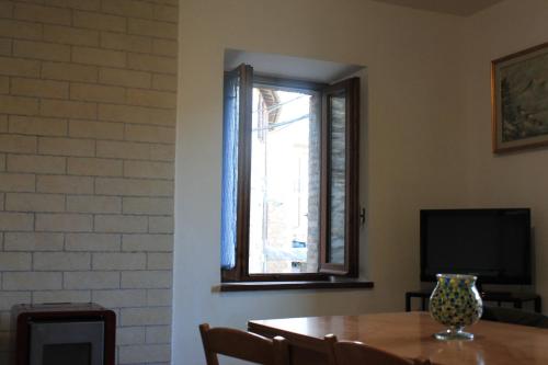 a dining room with a table and a window at La Torre di Melezzole in Melezzole