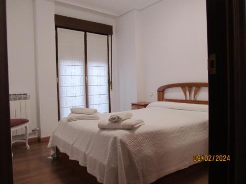 Un dormitorio con una cama con toallas. en OLIVO 75, en Leza