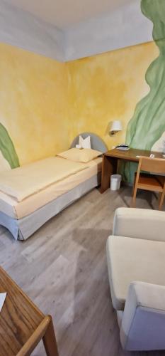 a room with two beds and a table and a couch at Goldener Schwan Hotel Garni in Bad Windsheim
