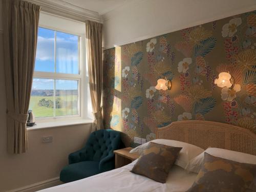 um quarto de hotel com uma cama e uma janela em Gwrach Ynys Country Guest House em Harlech