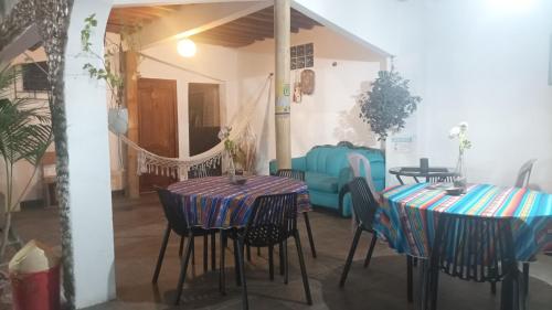 un comedor con 2 mesas y un sofá azul en Hostal Villa Brisa en Ballenita