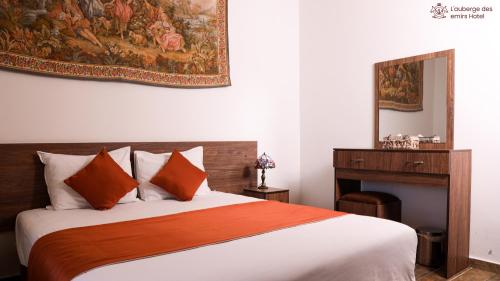1 dormitorio con 1 cama y una pintura en la pared en L'auberge des Emirs, en Dayr al Qamar