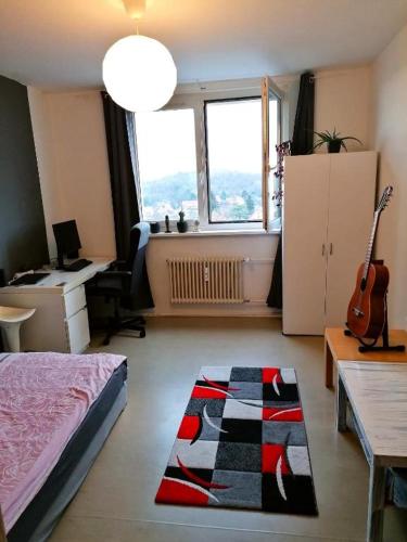 a room with a bed and a desk and a guitar at 20m² Cozy Nice Room 12 min. near the center Alexandeplatz in Berlin