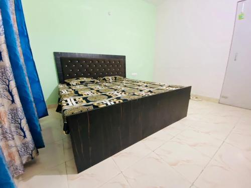 łóżko w pokoju z czarnym łóżkiem w obiekcie NapStayz 5.0 w mieście Lucknow