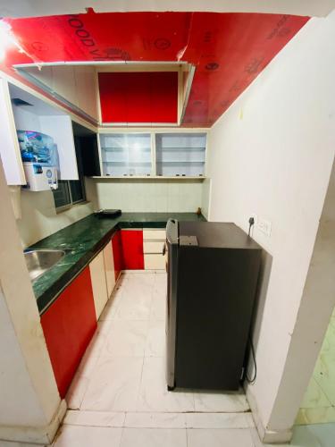 kuchnia z czerwono-białymi szafkami i zlewem w obiekcie NapStayz 5.0 w mieście Lucknow