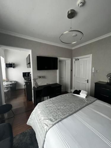 a bedroom with a large white bed and a desk at Amani Apartments - Glasgow City Centre in Glasgow