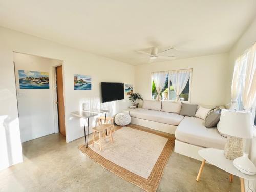 sala de estar con sofá blanco y TV en Akule Clubhouse, en Waialua